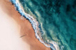 © AmazingAerialAgency - Aerial view of a white sandy beach with white waves rolling onto shore and crystal clear blue water and a girl standing on the beach casting a long shadow, Port Noarlunga, South Australia, Australia.
