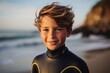 © Nerea - Portrait of a smiling boy with wetsuit at the beach