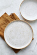 Two empty plates and brown napkin on light table. Top view, close up, flat lay.