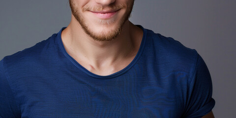 Close up portrait of young smiling handsome guy in blue t-shirt isolated on grey background