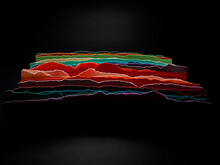 Abstract Stack Of Strips Of Multi Coloured Paper Against A Black Background