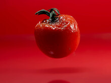 Close-up Of A Mouldy Tomato Against A Red Background