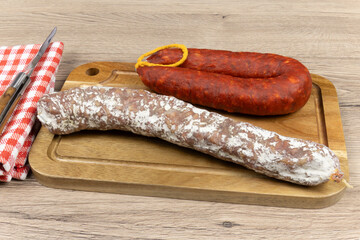 Sticker - saucisson sec et chorizo en gros plan, sur une planche à découper