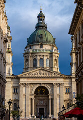 Wall Mural - St. Stephen Basilica dome rising above old buildings in the city center of Budapest, Hungary, photographed against cloudy sky