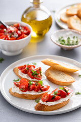 Wall Mural - Making tomato basil crostini or bruschetta with toasted baguette