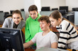 © JackF - Friendly female teacher and positive teen students looking at monitor screen during lesson in computer lab at school library ..