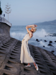 Sticker - Serene Summer Beauty: Young Female Model in a White Dress, Enjoying a Relaxing Evening Alone on a Sunny Beach with a Romantic Sunset Over the Calm Ocean