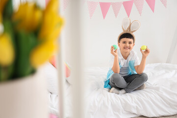 Canvas Print - Cute little boy wearing bunny ears with Easter eggs at home