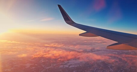 Wall Mural - airplane fly over snowy mountain hills during scenic sunrise with color sky cloudscape , view from p
