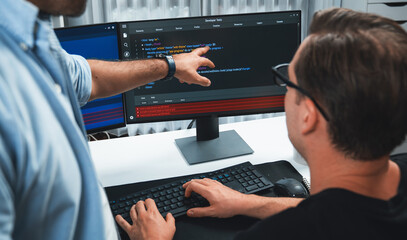 it developers pointing on software development information on two screens with coding program in app