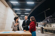 © qunica.com - A focused group of three colleagues in a deep conversation at an outdoor urban setting with paperwork and glowing evening lights.