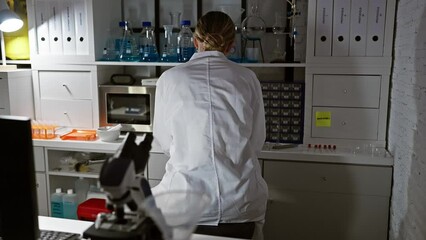 Poster - A focused woman scientist using a microscope in a modern laboratory setting.