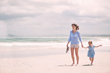 Wall Mural - Mother, child and hand holding on beach travel or explore environment or windy summer or holiday, weekend or bonding. Female person, daughter and relax at Australia seaside or peace, vacation or trip