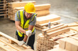 © chokniti - Engineer team standing walking in warehouse examining hardwood material for wood furniture production, Worker check stock, Technician man and woman working on quality control in lumber pallet factory