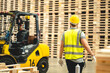 © chokniti - Engineer team standing walking in warehouse examining hardwood material for wood furniture production, Worker check stock, Technician man and woman working on quality control in lumber pallet factory