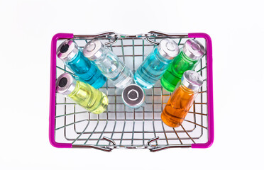 Glass vials of different colors for the vaccine in the shopping cart on a white background. Copy space. Selective focus.