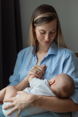 motherhood concept, happy young mother looking tenderly at her baby, mother's day background