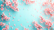 Beautiful pink cherry flowers forming a frame on a pastel blue background, copy space for your text