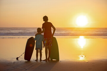 Sticker - Happy children, boys, playing on the beach on sunset, kid cover in sand, smiling, laughing