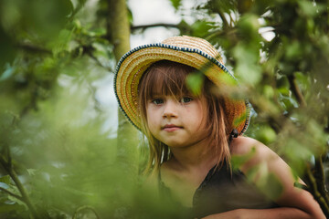 Wall Mural - Close-up portrait of a sweet little girl in the garden.