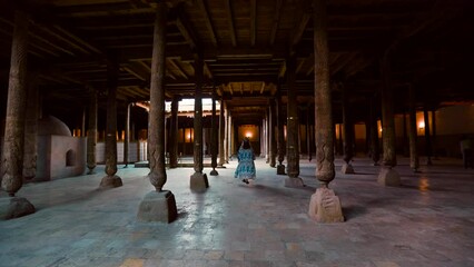 Wall Mural - Woman in the Hall of wooden columns in Juma Mosque in Khiva