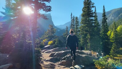 woman hiking through rocky mountain national park in colorado
