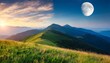 day and night time change concept above mountain landscape in summer grassy meadows on the hills rolling in to the distant peak beneath sky with sun and moon