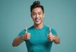 An athletic man in a teal shirt gives two thumbs up, his bright smile and sporty appearance suggesting a dynamic and healthy lifestyle.
