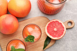 Fototapeta Kuchnia - Tasty freshly made grapefruit juice, fruits and mint on light grey table, flat lay