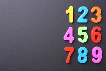 Poster - Colorful numbers on dark gray background, flat lay. Space for text