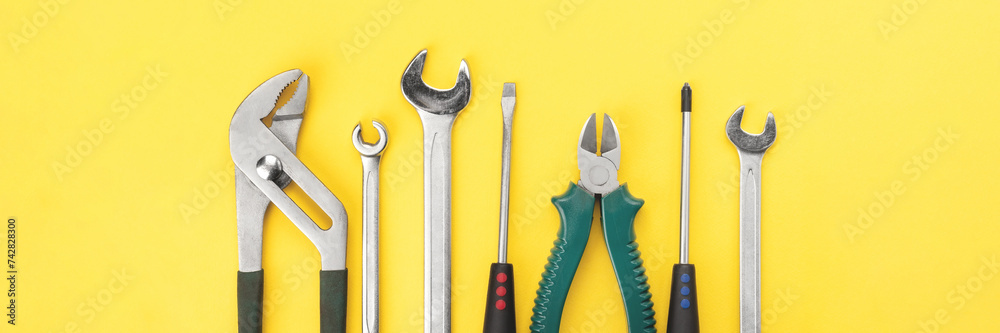 Work tools on bright yellow background banner. Panoramic web header ...