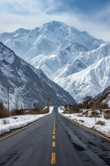 Wall Mural - The road is empty and there are snow mountains in the background.