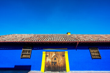 Poster - Blue colonial building set against a blue sky in the historic center of Bogota, Colombia