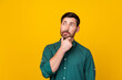 © deagreez - Portrait of minded clever man with beard wear stylish shirt thoughtfully look at empty space isolated on vivid yellow color background
