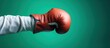 Hand in boxing glove kicking cigarette on green background.