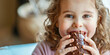 A child, eyes alight with joy, delicately savors a chocolate Easter egg, 