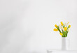 white and yellow spring flowers  in vase on white background