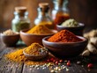 Close-up variety of spices, dust or grain in bottle and in bowl, culinary ingredients on wooden table. Assorted spices and grains on wood surface