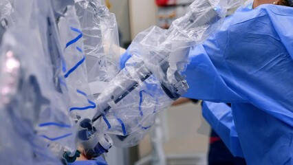 Wall Mural - Female first assistant managing the robotic equipment. Attaching the manipulator arms to the patient's body.