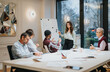 © qunica.com - Focused team members in a light-flooded office during a business presentation. The professional atmosphere is clear as a dedicated woman leads the discussion.
