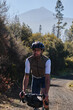 © KatyaPulka - Fit male cyclist riding a gravel bike a gravel road with view on Teide volcano. Cyclist training on beautiful forest trail. Sport motivation. Adventure travel on bike. Tenerife, Canary Island.