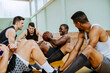 © Marko Geber - Exhausted basketball player resting on the court with teammates
