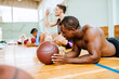 © Marko Geber - Exhausted basketball player resting on the court with teammates