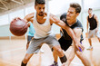 © Marko Geber - Men playing basketball in indoor gym