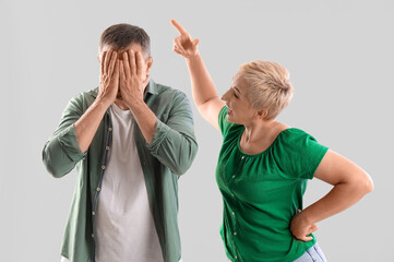 Wall Mural - Mature couple quarreling on light background