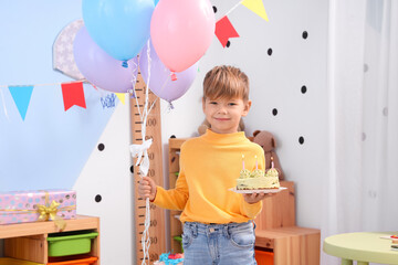 Wall Mural - Cute little boy with cake and balloons celebrating Birthday at home