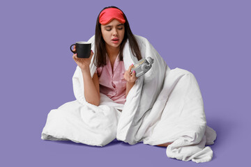 Canvas Print - Beautiful young woman with blanket, cup of coffee and alarm clock sitting on purple background