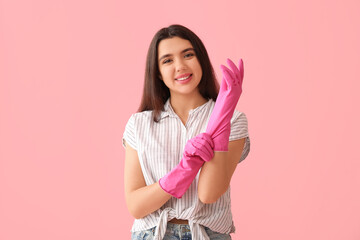 Sticker - Young woman with rubber gloves on pink background