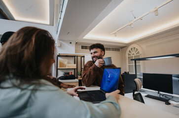 Poster - Colleagues sharing a light-hearted moment with coffee during work.