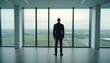 business person standing in front of office window, looking outside. wide view. 